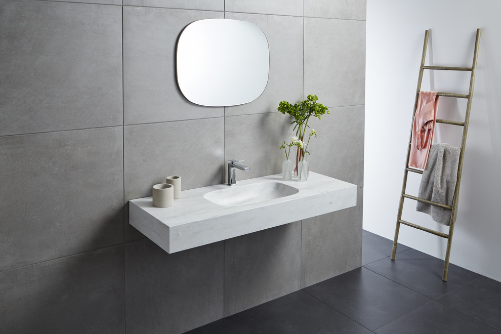Foto di una stanza da bagno scandinava con lavabo integrato e top in superficie solida