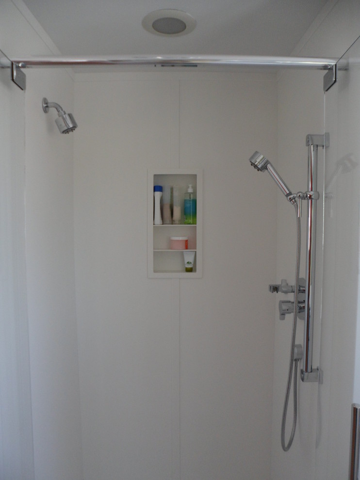 Idéer för att renovera ett litet funkis badrum med dusch, med släta luckor, vita skåp, bänkskiva i akrylsten, grå kakel, stenkakel, en dusch i en alkov, en toalettstol med hel cisternkåpa, ett integrerad handfat, grå väggar och marmorgolv