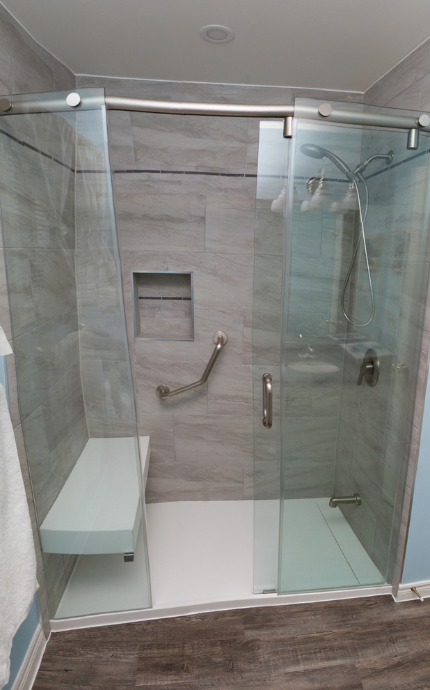 Esempio di una stanza da bagno con doccia contemporanea di medie dimensioni con ante di vetro, piastrelle grigie, piastrelle in gres porcellanato e top in superficie solida