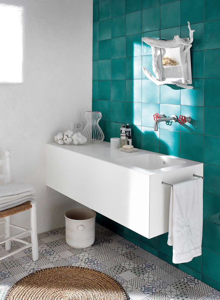 Cette image montre une salle de bain méditerranéenne avec un plan de toilette en surface solide.