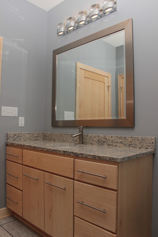 Пример оригинального дизайна: ванная комната в стиле модернизм с светлыми деревянными фасадами, серыми стенами, полом из керамогранита, врезной раковиной, столешницей из гранита, серой плиткой и керамогранитной плиткой