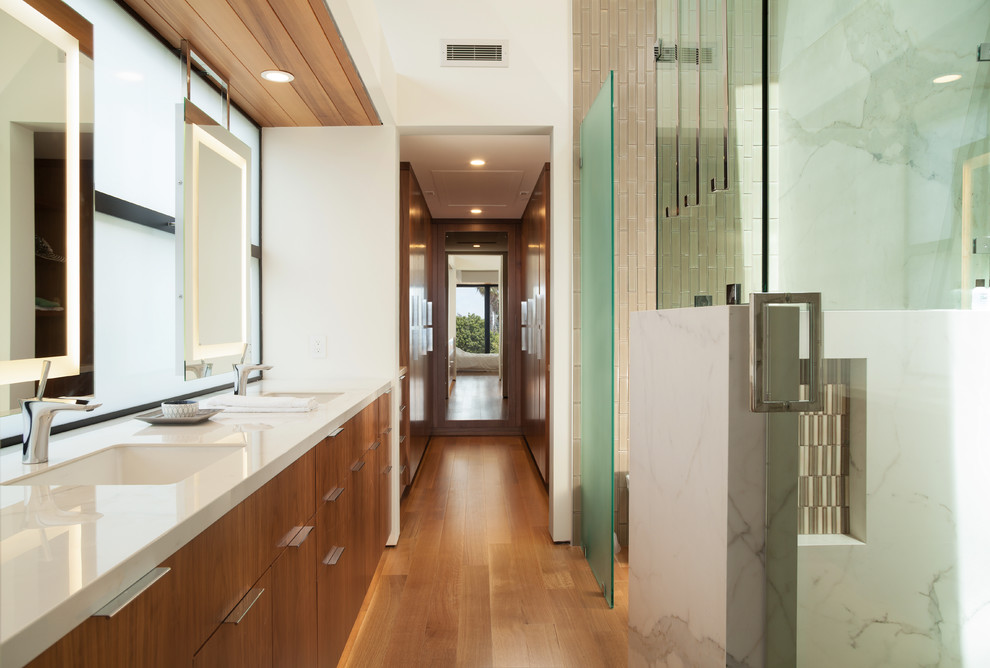 Inspiration for a mid-sized modern master concrete floor and gray floor bathroom remodel in Orange County with flat-panel cabinets, medium tone wood cabinets, a one-piece toilet, white walls, an undermount sink and quartz countertops