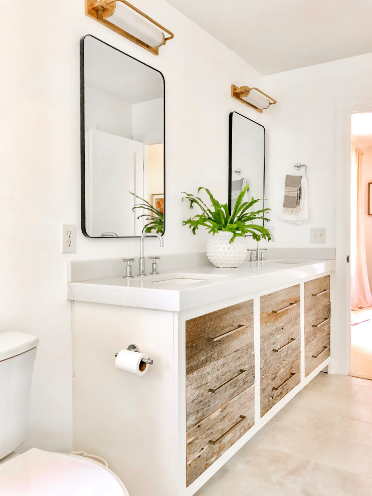 Medium sized coastal ensuite bathroom in Charlotte with flat-panel cabinets, distressed cabinets, a freestanding bath, an alcove shower, white tiles, porcelain tiles, white walls, porcelain flooring, a submerged sink, engineered stone worktops, beige floors, a hinged door, white worktops, double sinks and a built in vanity unit.