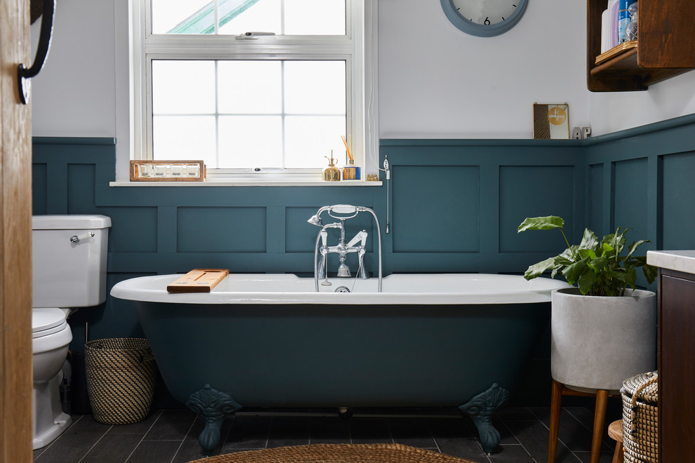 Inspiration for a contemporary bathroom in London with flat-panel cabinets, dark wood cabinets, a claw-foot bath, white walls, a vessel sink, grey floors and white worktops.