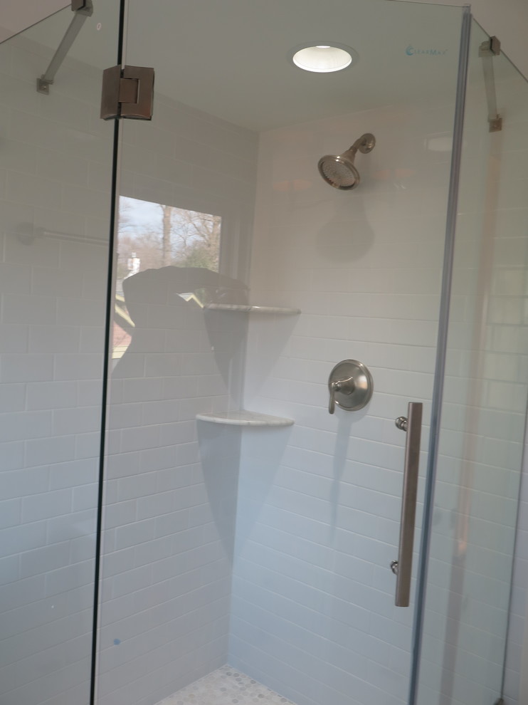ワシントンD.C.にある高級な小さなトランジショナルスタイルのおしゃれなバスルーム (浴槽なし) (レイズドパネル扉のキャビネット、白いキャビネット、コーナー設置型シャワー、分離型トイレ、白いタイル、サブウェイタイル、青い壁、モザイクタイル、アンダーカウンター洗面器、大理石の洗面台、開き戸のシャワー、黄色い床) の写真