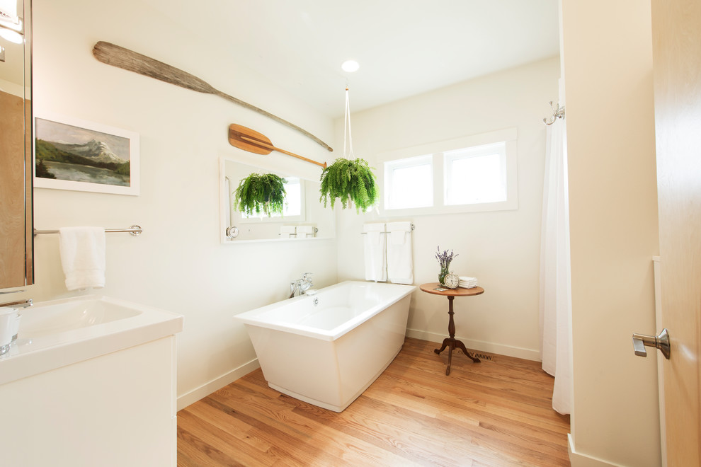 Foto di una stanza da bagno contemporanea con ante lisce, ante bianche, vasca freestanding, pareti bianche, pavimento in legno massello medio, lavabo a consolle e pavimento marrone