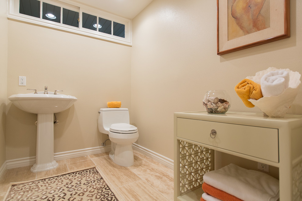 This is an example of a small classic shower room bathroom in Orange County with a pedestal sink, an alcove shower, a two-piece toilet, stone tiles, beige walls, marble flooring and beige tiles.