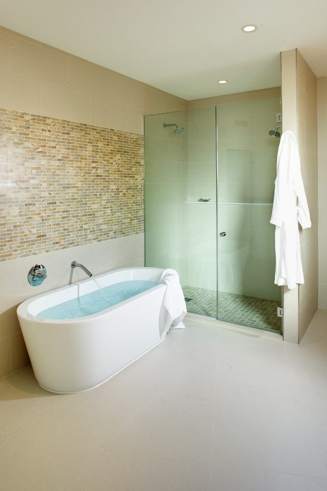 Large contemporary ensuite bathroom in Orange County with flat-panel cabinets, light wood cabinets, a freestanding bath, an alcove shower, beige tiles, brown tiles, grey tiles, porcelain tiles, a submerged sink, engineered stone worktops, a one-piece toilet, beige walls and porcelain flooring.