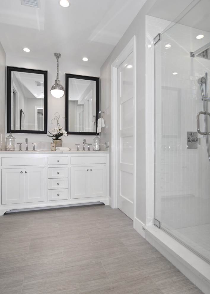 Idéer för ett mellanstort modernt en-suite badrum, med skåp i shakerstil, vita skåp, vit kakel, grå väggar, en dusch i en alkov, tunnelbanekakel, klinkergolv i porslin, ett undermonterad handfat, marmorbänkskiva, beiget golv och dusch med gångjärnsdörr