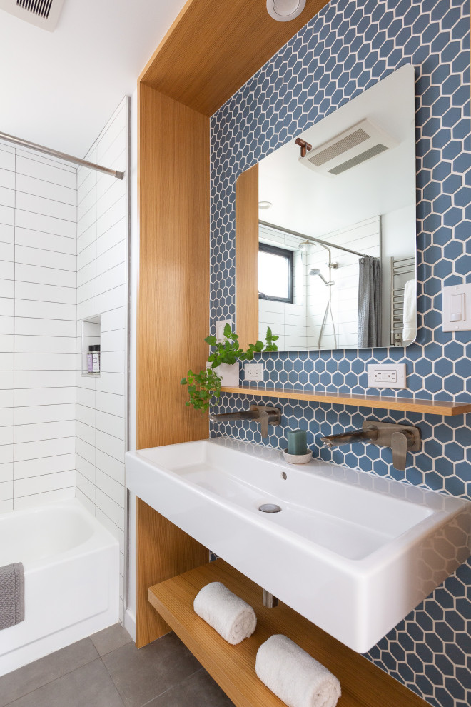 Inredning av ett modernt mellanstort vit vitt badrum med dusch, med öppna hyllor, ett badkar i en alkov, en dusch i en alkov, blå kakel, porslinskakel, klinkergolv i porslin, ett avlångt handfat, grått golv och dusch med duschdraperi