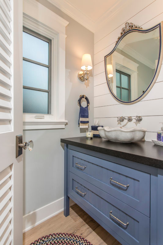 Mid-sized elegant 3/4 light wood floor and brown floor bathroom photo in San Diego with shaker cabinets, blue cabinets, a one-piece toilet, white walls, a vessel sink and quartz countertops