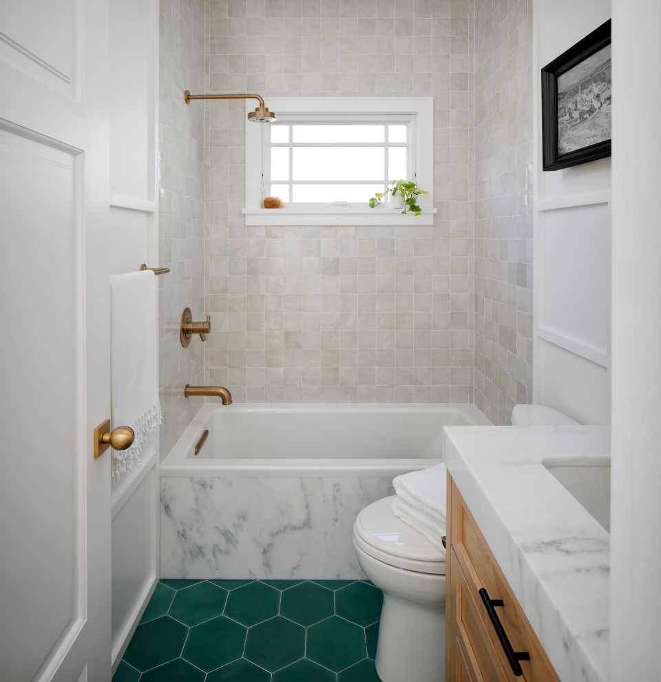 Inredning av ett klassiskt litet grå grått badrum för barn, med skåp i shakerstil, bruna skåp, en dusch/badkar-kombination, grå kakel, cementkakel, vita väggar, cementgolv, ett undermonterad handfat, marmorbänkskiva, dusch med duschdraperi, ett badkar i en alkov och grönt golv