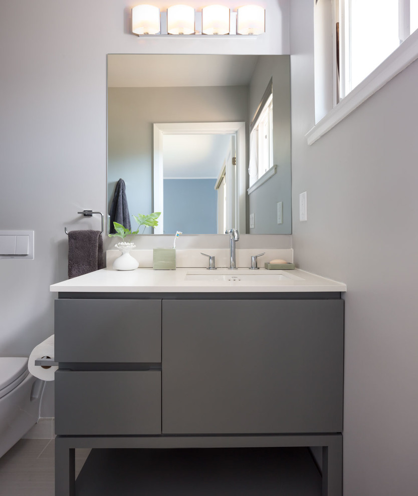 Alcove shower - small contemporary 3/4 beige tile slate floor and gray floor alcove shower idea in San Francisco with flat-panel cabinets, quartz countertops, a one-piece toilet, beige walls, gray cabinets, a hinged shower door and an undermount sink