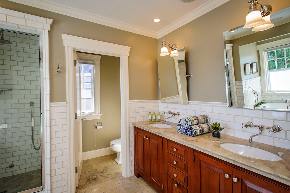 На фото: ванная комната в классическом стиле с врезной раковиной, фасадами с выступающей филенкой, фасадами цвета дерева среднего тона, душем в нише, белой плиткой и плиткой кабанчик