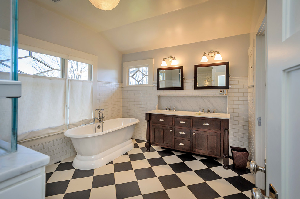 Пример оригинального дизайна: большая главная ванная комната в стиле кантри с врезной раковиной, темными деревянными фасадами, отдельно стоящей ванной, угловым душем, белой плиткой, плиткой кабанчик, серыми стенами, мраморной столешницей, разноцветным полом и фасадами в стиле шейкер