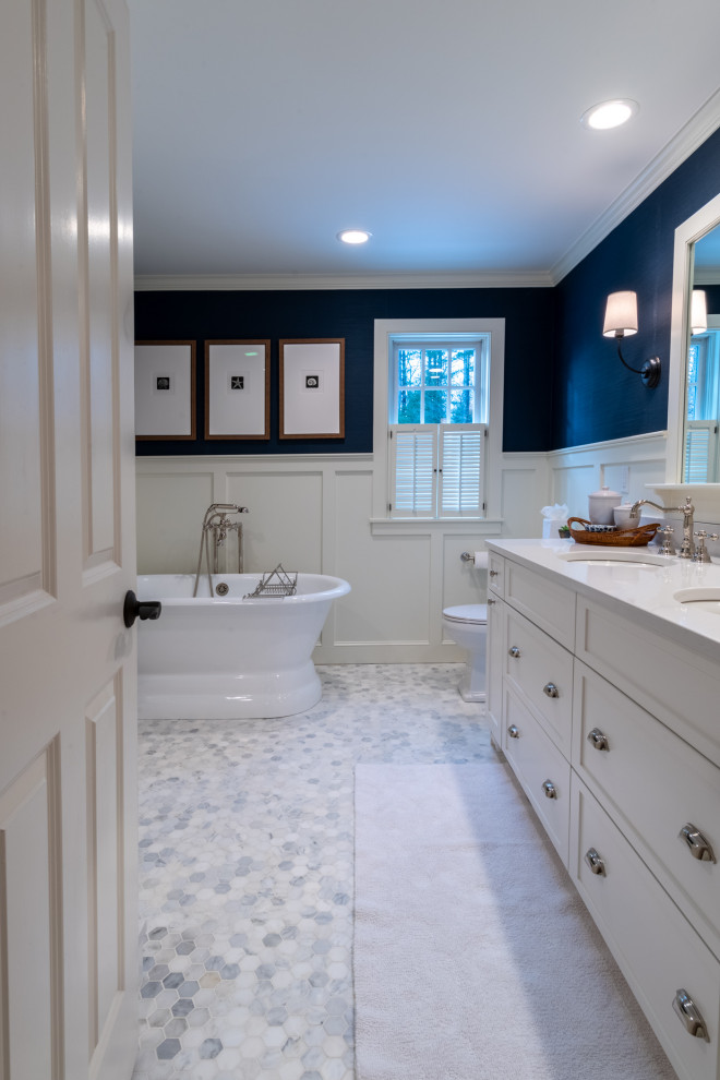 Свежая идея для дизайна: большая главная ванная комната в стиле неоклассика (современная классика) с фасадами с утопленной филенкой, белыми фасадами, отдельно стоящей ванной, двойным душем, раздельным унитазом, синими стенами, врезной раковиной, столешницей из искусственного кварца, душем с распашными дверями и белой столешницей - отличное фото интерьера
