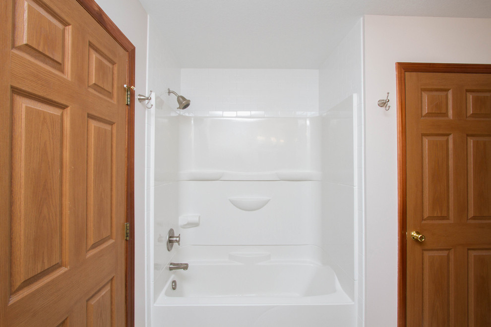Aménagement d'une grande salle de bain principale classique en bois brun avec un placard avec porte à panneau encastré, une baignoire en alcôve, un combiné douche/baignoire, WC séparés, un carrelage blanc, un carrelage de pierre, un mur gris, un sol en vinyl, un lavabo encastré et un plan de toilette en granite.