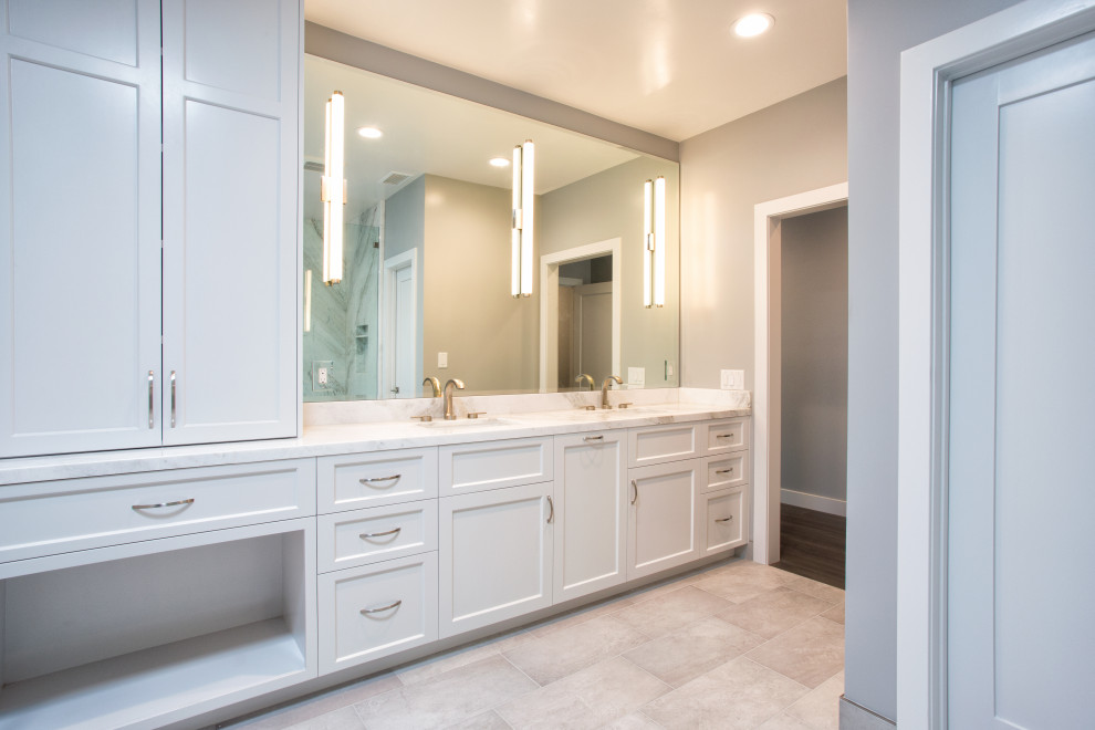 Design ideas for a medium sized contemporary ensuite bathroom in Orange County with shaker cabinets, white cabinets, a built-in shower, a two-piece toilet, grey tiles, marble tiles, grey walls, ceramic flooring, a submerged sink, marble worktops, grey floors, a hinged door, grey worktops, a shower bench, double sinks and a built in vanity unit.