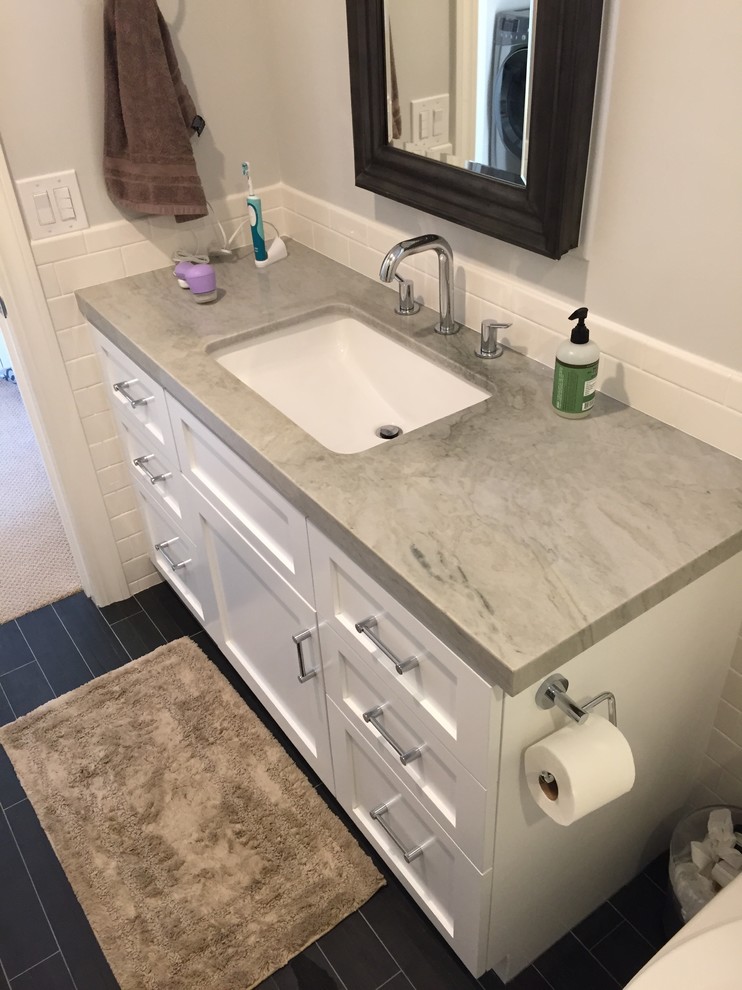 This is an example of a small traditional shower room bathroom in Orange County with shaker cabinets, white cabinets, an alcove shower, a one-piece toilet, white tiles, ceramic tiles, white walls, porcelain flooring, a submerged sink, quartz worktops, black floors, a hinged door and grey worktops.