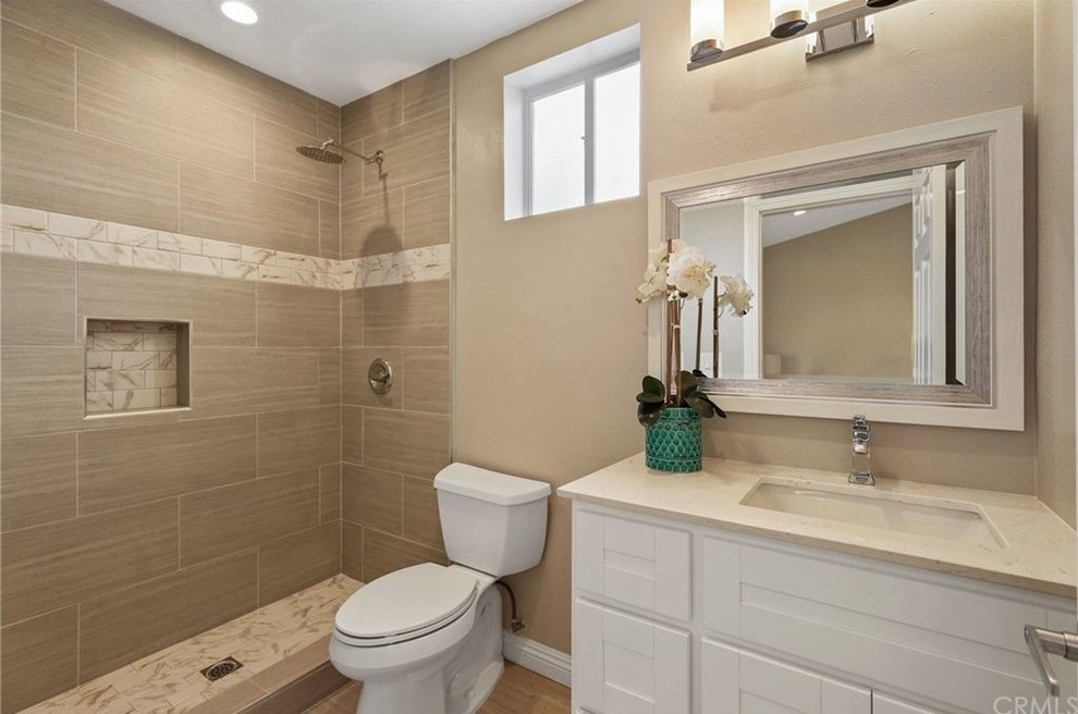 Idéer för mellanstora en-suite badrum, med skåp i shakerstil, vita skåp, en öppen dusch, en toalettstol med separat cisternkåpa, brun kakel, porslinskakel, grå väggar, klinkergolv i porslin, ett undermonterad handfat, bänkskiva i kvarts och brunt golv