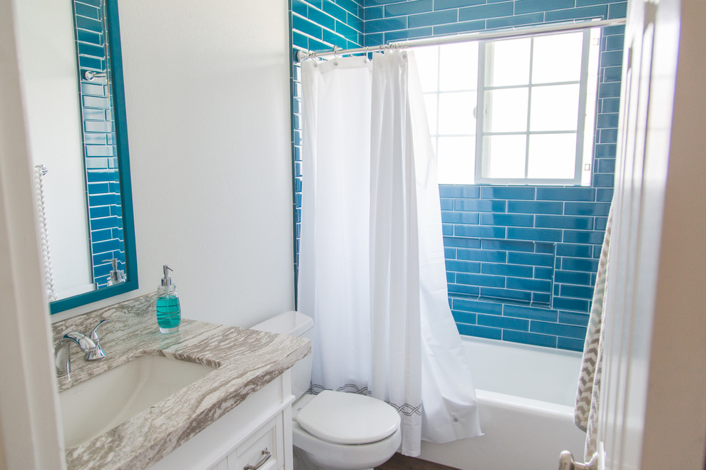 Idéer för att renovera ett mellanstort vintage badrum med dusch, med skåp i shakerstil, vita skåp, ett badkar i en alkov, en dusch/badkar-kombination, en toalettstol med separat cisternkåpa, blå kakel, tunnelbanekakel, vita väggar, mörkt trägolv, ett undermonterad handfat, bänkskiva i kvartsit, brunt golv och dusch med duschdraperi