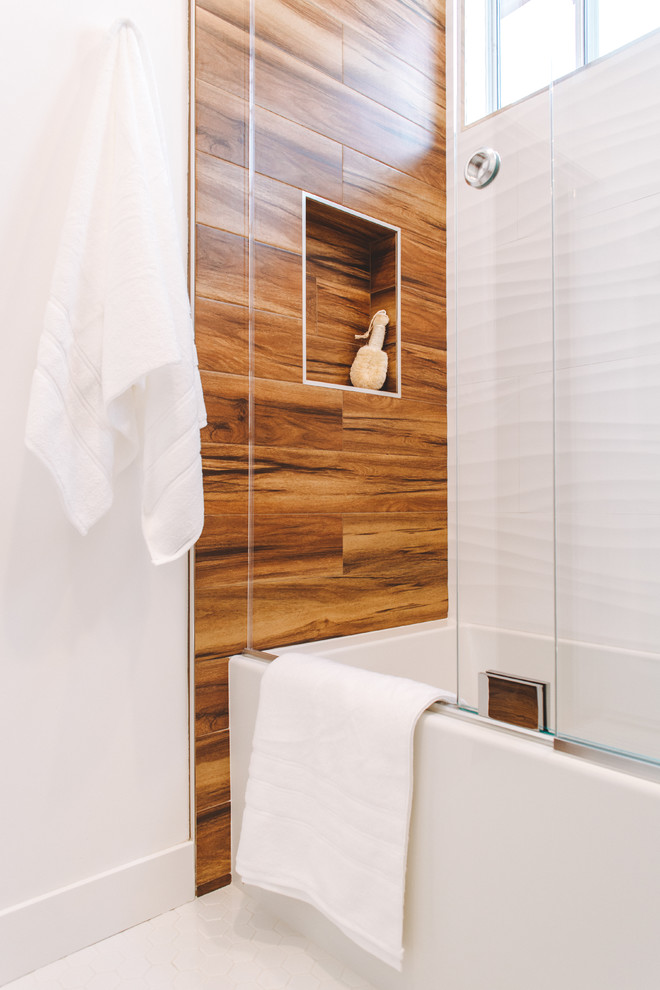 Aménagement d'une petite salle d'eau contemporaine en bois brun avec un placard en trompe-l'oeil, une baignoire en alcôve, un combiné douche/baignoire, WC à poser, un mur blanc, un sol en carrelage de céramique, une vasque, un plan de toilette en verre, un sol blanc et une cabine de douche à porte coulissante.