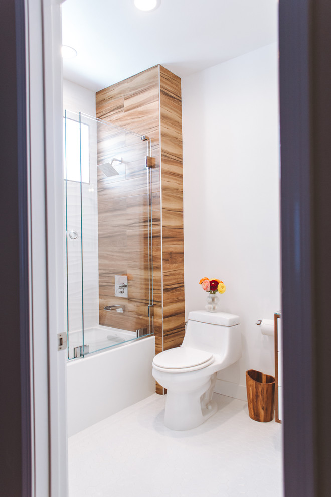 Cette image montre une petite salle d'eau design en bois brun avec un placard en trompe-l'oeil, une baignoire en alcôve, un combiné douche/baignoire, WC à poser, un mur blanc, un sol en carrelage de céramique, une vasque, un plan de toilette en verre, un sol blanc et une cabine de douche à porte coulissante.