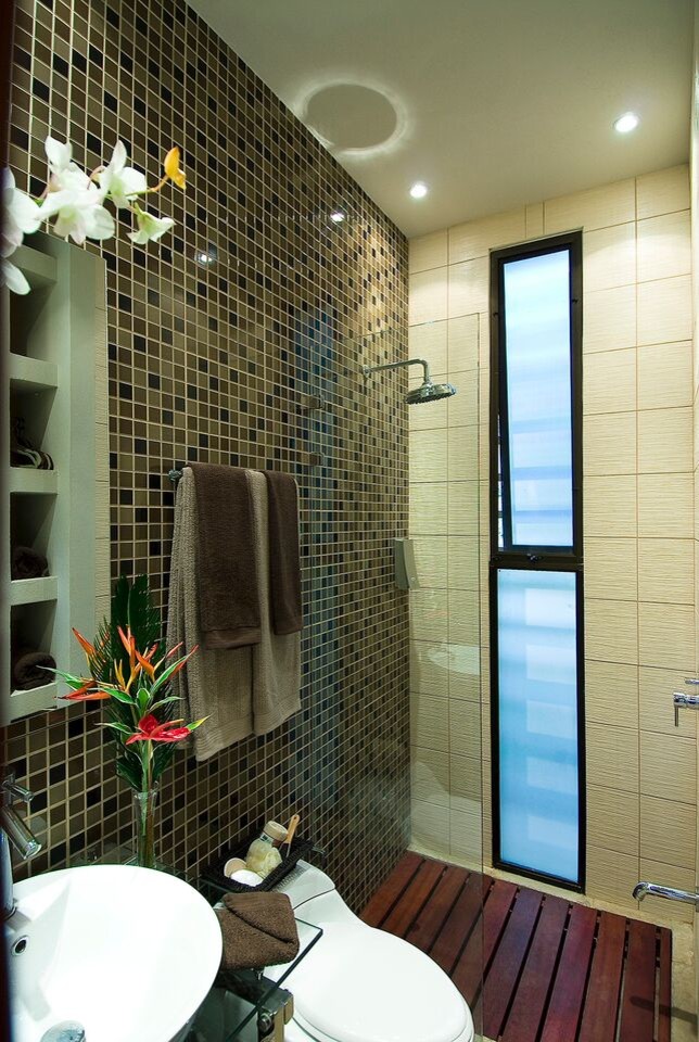 Exemple d'une grande salle de bain principale tendance avec un placard sans porte, une douche d'angle, un mur beige, un plan de toilette en verre, un sol gris et aucune cabine.