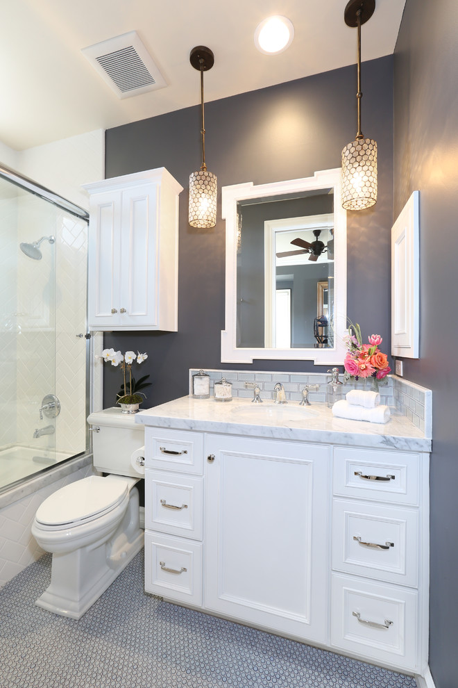 Réalisation d'une salle de bain grise et blanche tradition avec une baignoire en alcôve, un combiné douche/baignoire, WC séparés, des portes de placard blanches et un mur gris.