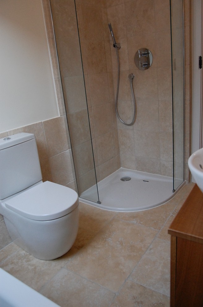 Idée de décoration pour une petite salle de bain principale champêtre en bois brun avec un placard en trompe-l'oeil, une baignoire encastrée, WC suspendus, un carrelage beige, un carrelage de pierre, un mur blanc, un sol en travertin et un lavabo encastré.