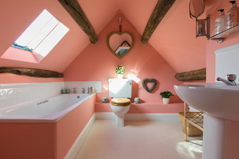 На фото: ванная комната в стиле кантри с накладной ванной, унитазом-моноблоком, розовыми стенами и раковиной с пьедесталом