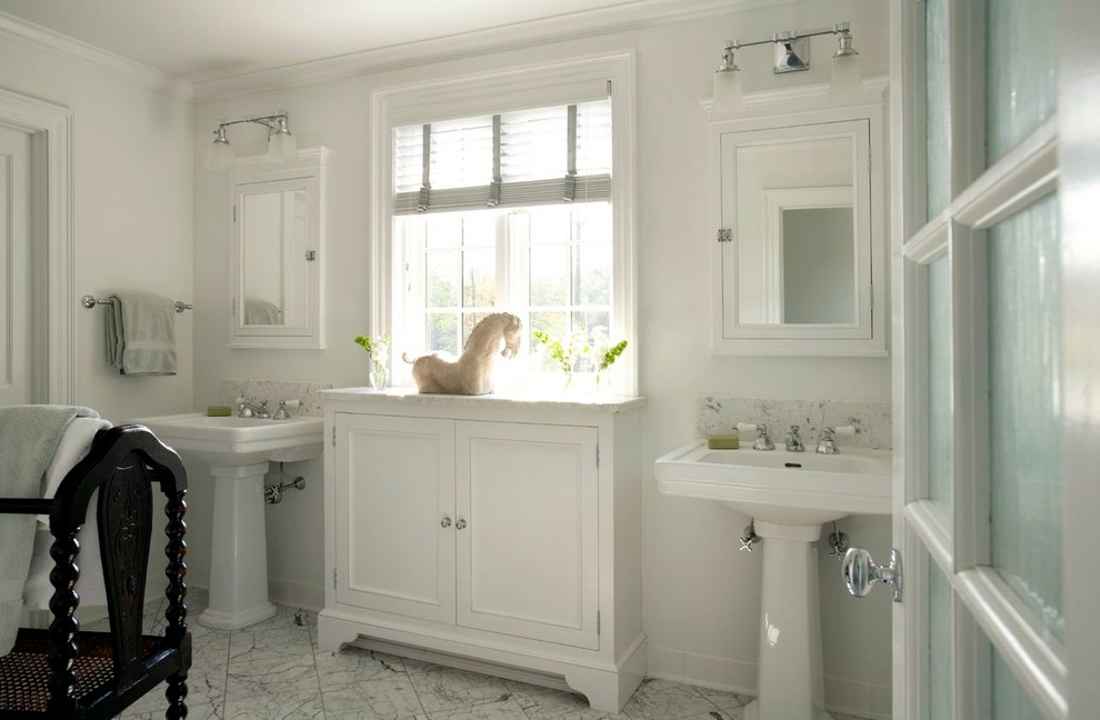 Modelo de cuarto de baño clásico de tamaño medio con armarios con paneles con relieve, puertas de armario blancas, paredes blancas, suelo blanco y lavabo con pedestal