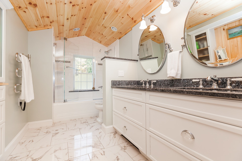 Bathroom - mid-sized traditional master white tile and porcelain tile bathroom idea in Boston with recessed-panel cabinets, white cabinets, a two-piece toilet, an undermount sink, granite countertops, gray walls and a hinged shower door
