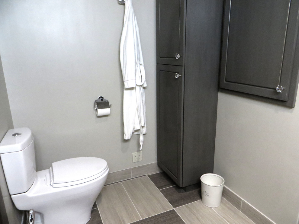 Cette image montre une salle de bain principale chalet de taille moyenne avec un lavabo de ferme, un placard en trompe-l'oeil, des portes de placard grises, un plan de toilette en marbre, WC séparés, un carrelage gris, des carreaux de porcelaine, un mur gris et un sol en carrelage de porcelaine.