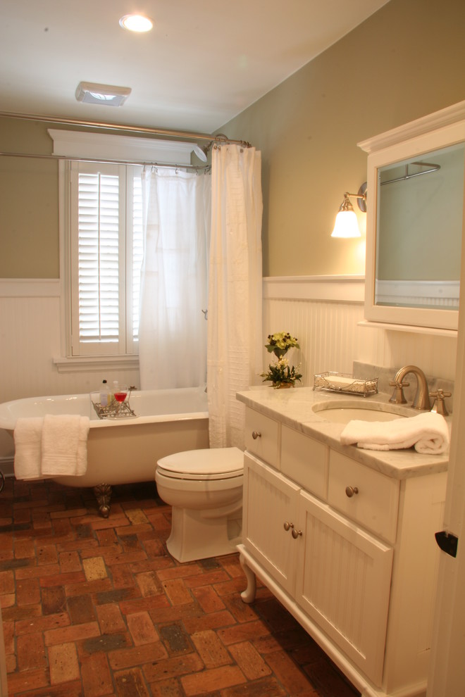 Modelo de cuarto de baño de estilo americano de tamaño medio con armarios con paneles lisos, puertas de armario blancas, encimera de granito y suelo de ladrillo