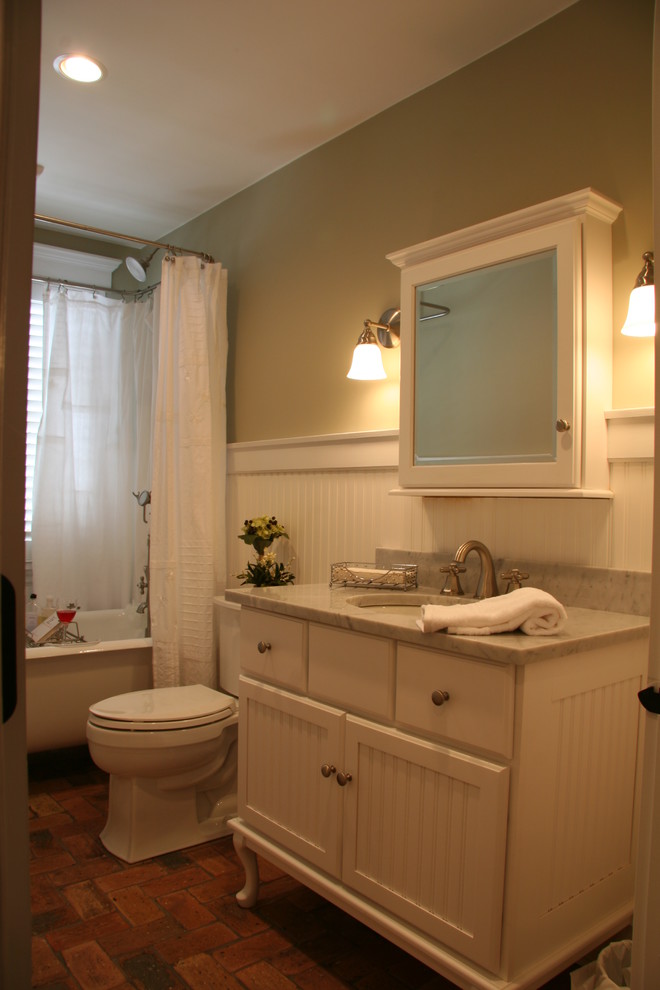 На фото: ванная комната среднего размера в стиле кантри с плоскими фасадами, белыми фасадами, столешницей из гранита и кирпичным полом с