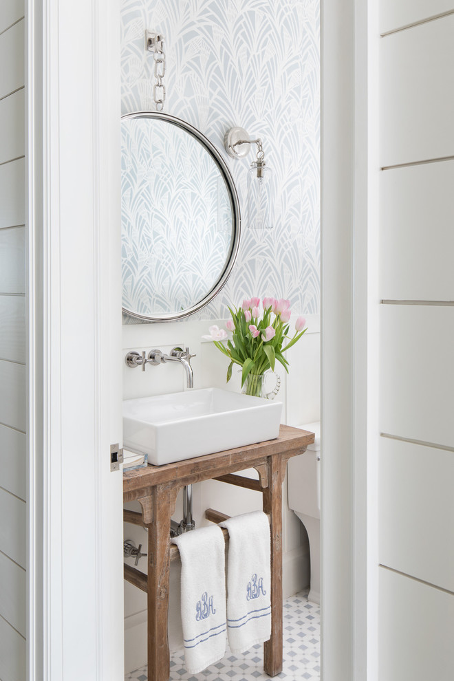 Imagen de cuarto de baño costero con puertas de armario de madera oscura, paredes blancas, lavabo sobreencimera, encimera de madera, suelo blanco y encimeras marrones