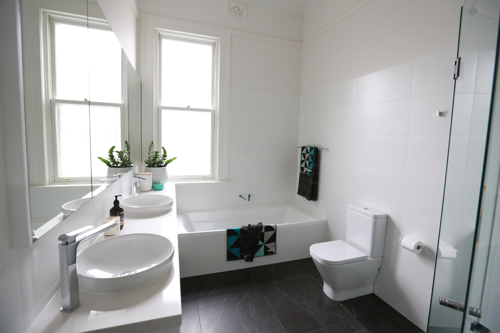 Idéer för mellanstora funkis badrum, med vita skåp, ett platsbyggt badkar, en hörndusch, en toalettstol med hel cisternkåpa, svart och vit kakel, keramikplattor, vita väggar, klinkergolv i keramik, ett nedsänkt handfat och granitbänkskiva
