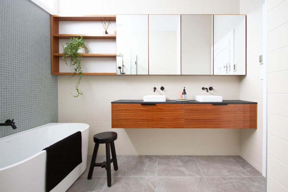 Aménagement d'une salle de bain contemporaine en bois brun de taille moyenne avec une baignoire indépendante, une douche d'angle, un carrelage multicolore, mosaïque, un mur bleu, carreaux de ciment au sol, une vasque, un plan de toilette en granite, un sol gris et un plan de toilette gris.