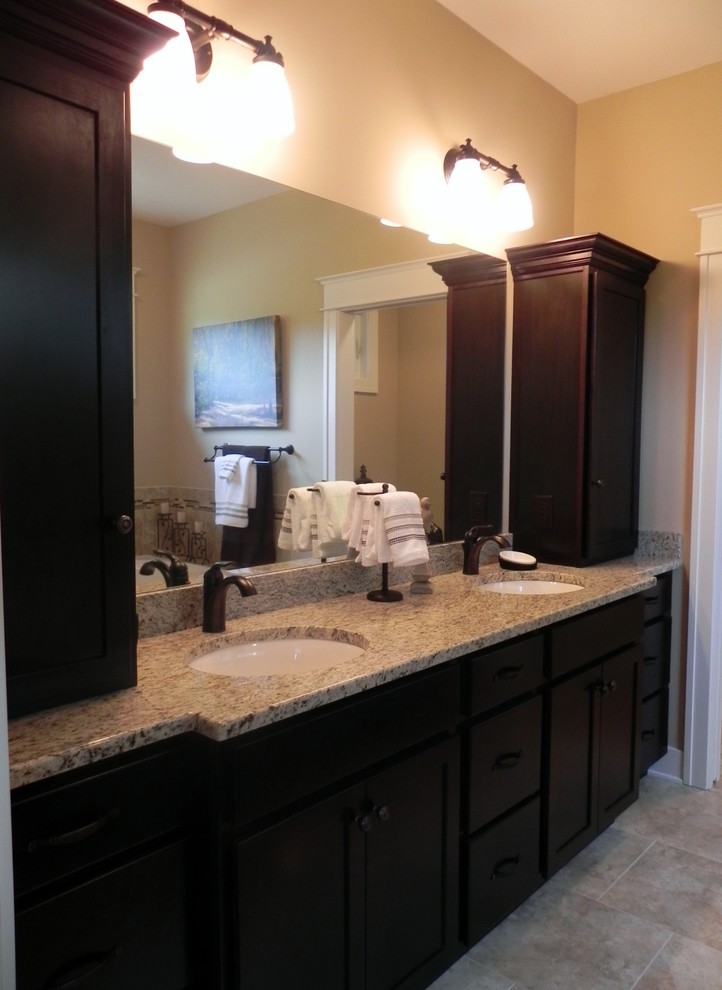 Imagen de cuarto de baño principal clásico de tamaño medio con lavabo bajoencimera, armarios con paneles empotrados, puertas de armario de madera en tonos medios y paredes beige