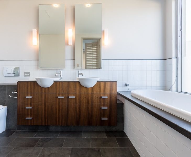 Стильный дизайн: главная ванная комната среднего размера в современном стиле с мраморной столешницей, белыми фасадами, инсталляцией, плиткой из известняка, серыми стенами, бетонным полом, настольной раковиной и серым полом - последний тренд
