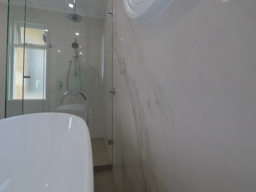 Photo of a large modern ensuite bathroom in Perth with shaker cabinets, white cabinets, a freestanding bath, a corner shower, a one-piece toilet, white tiles, ceramic tiles, white walls, porcelain flooring, a built-in sink, engineered stone worktops and a hinged door.