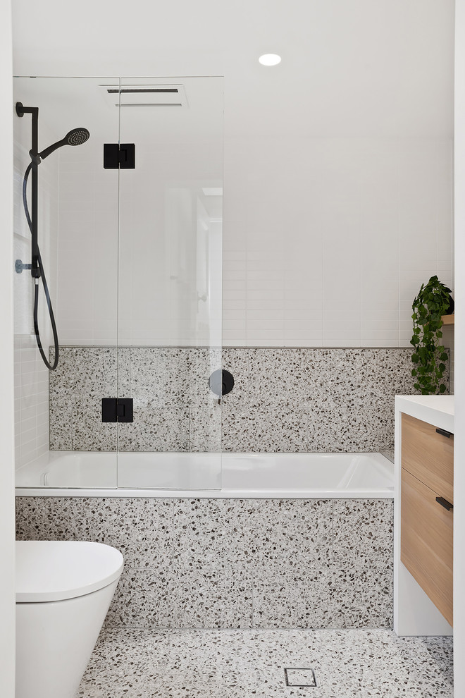 Small danish master white tile and porcelain tile porcelain tile and gray floor bathroom photo in Perth with flat-panel cabinets, light wood cabinets, a one-piece toilet, white walls, an undermount sink, quartz countertops, a hinged shower door and white countertops