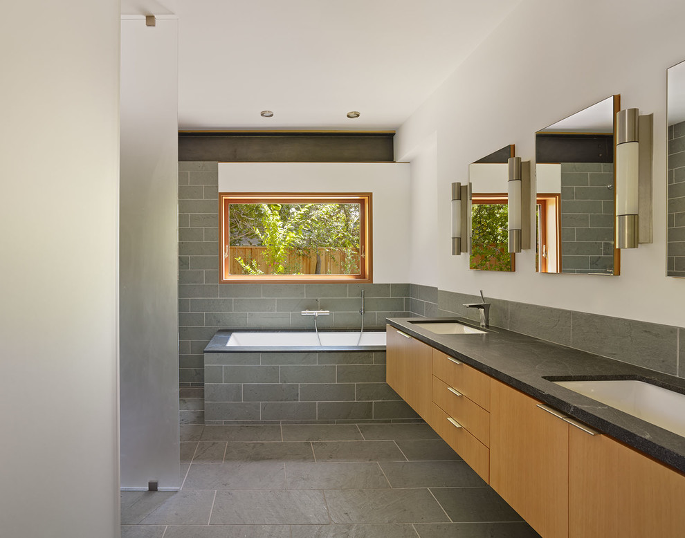 Idee per una stanza da bagno moderna con ante lisce, ante in legno scuro, vasca sottopiano, piastrelle grigie, pareti bianche, lavabo sottopiano, doccia aperta e top grigio
