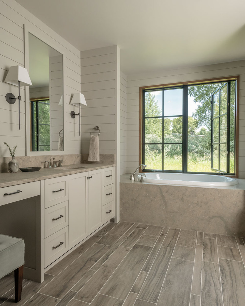 Ejemplo de cuarto de baño de estilo de casa de campo con armarios estilo shaker, puertas de armario blancas, bañera encastrada, lavabo bajoencimera, suelo gris y encimeras beige