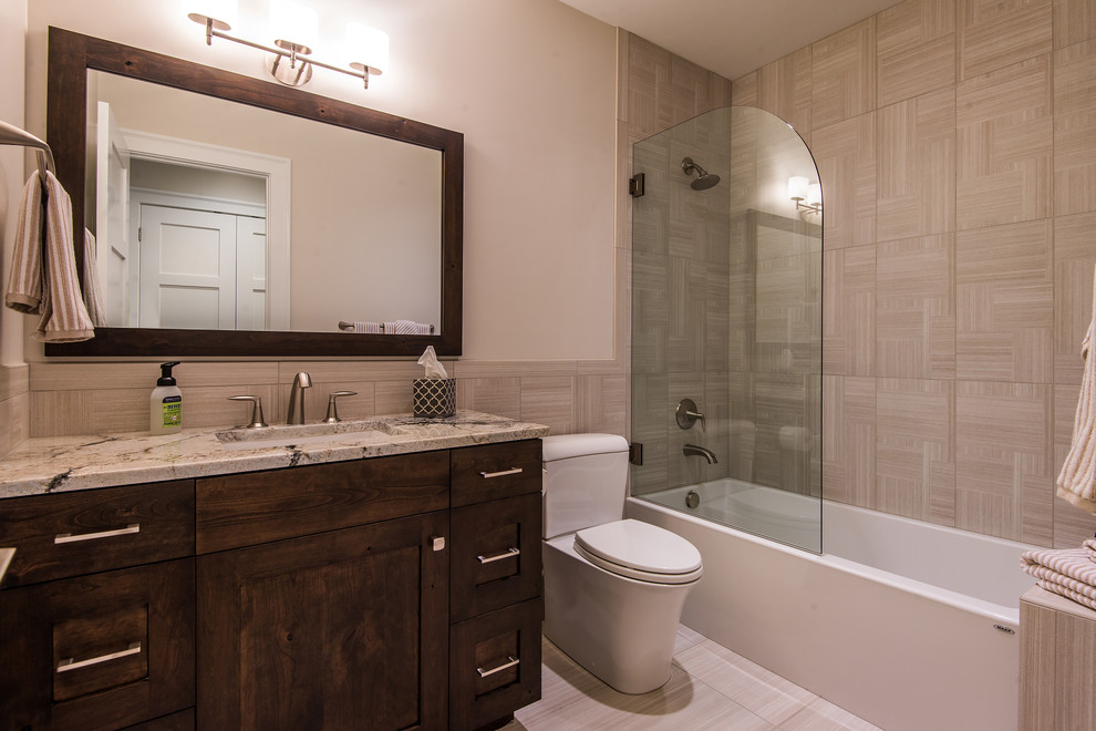 Mid-sized elegant beige tile tub/shower combo photo in Salt Lake City with shaker cabinets, a one-piece toilet, beige walls, an undermount sink and granite countertops