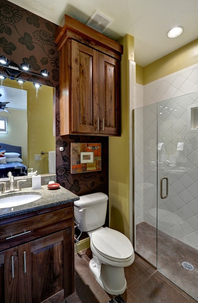 Foto på ett eklektiskt badrum, med skåp i mellenmörkt trä, granitbänkskiva, en kantlös dusch, vit kakel, keramikplattor och gula väggar