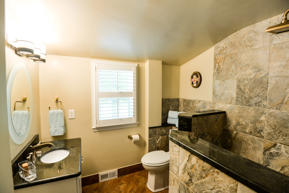 Photo of a small rustic family bathroom in Baltimore with a submerged sink, granite worktops, a walk-in shower, a two-piece toilet, green tiles, porcelain tiles, beige walls, porcelain flooring, recessed-panel cabinets, medium wood cabinets, a single sink and a freestanding vanity unit.