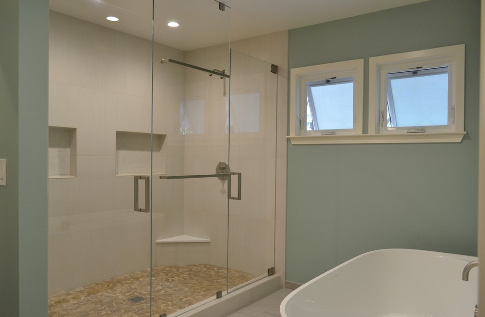 This is an example of a large modern ensuite bathroom in San Francisco with flat-panel cabinets, medium wood cabinets, a freestanding bath, a double shower, white tiles, porcelain tiles, green walls, porcelain flooring, an integrated sink, solid surface worktops, multi-coloured floors, a hinged door and white worktops.