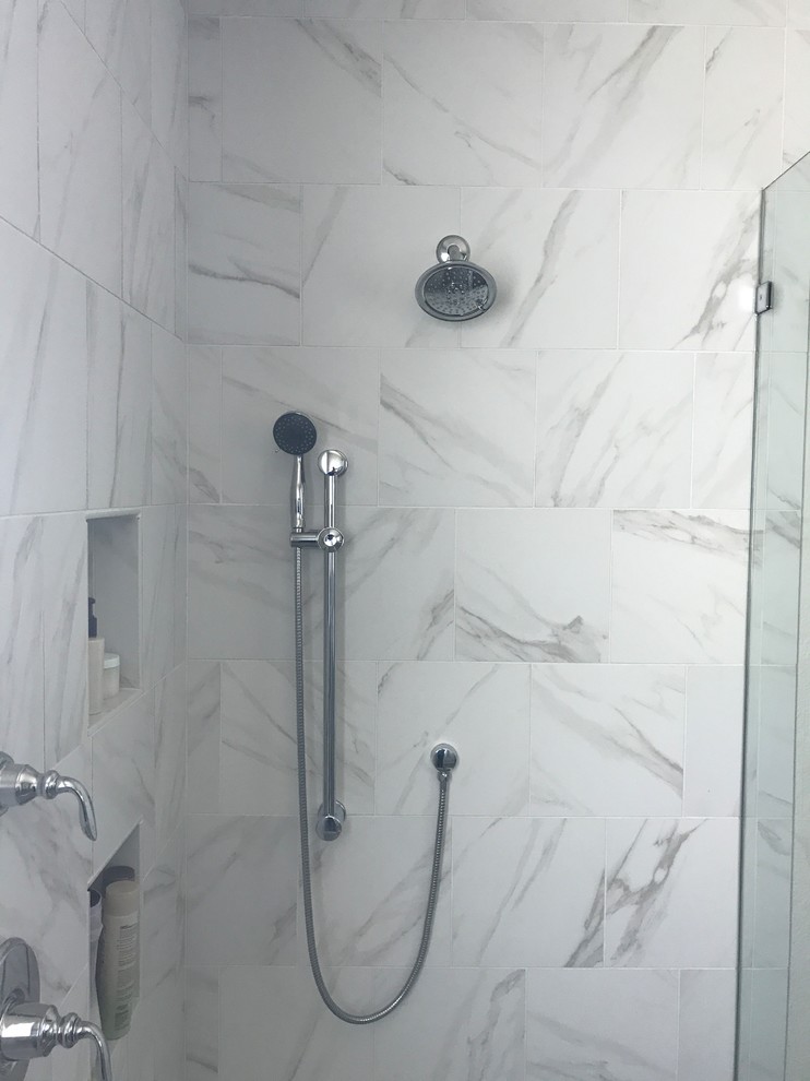 Cette image montre une grande salle de bain principale design avec WC séparés, un carrelage blanc, des carreaux de porcelaine, un mur blanc, un sol en carrelage de porcelaine, un sol marron et une cabine de douche à porte battante.